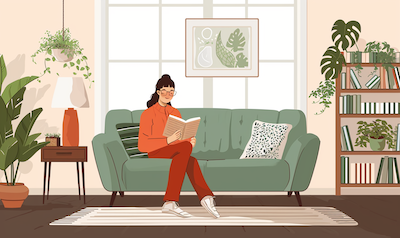 Frau sitzt auf einer Couch und liest ein Buch zwischen den Sprachkursen