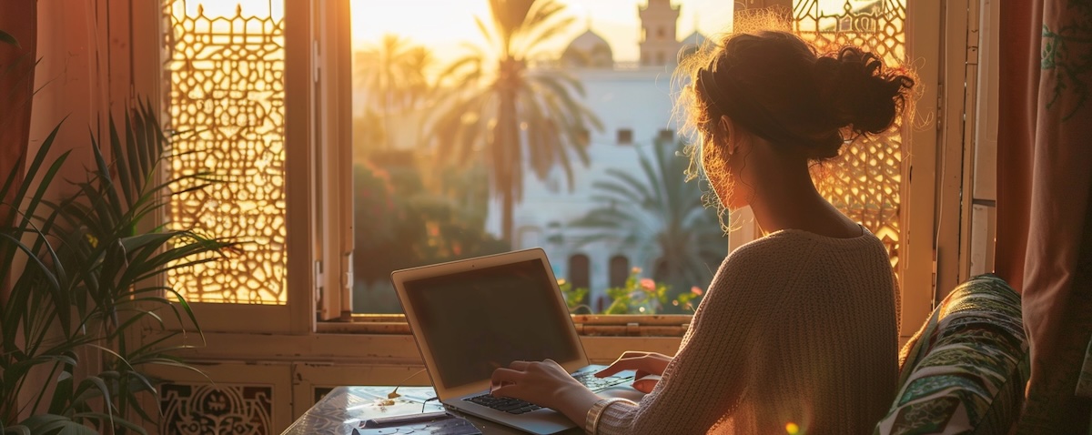 Person lernt Tunesisch am Laptop mit Blick auf eine tunesische Altstadt