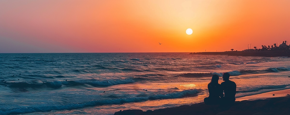Ich liebe dich auf Hebräisch – Paar-Silhouette am Strand von Tel Aviv im goldenen Abendlicht